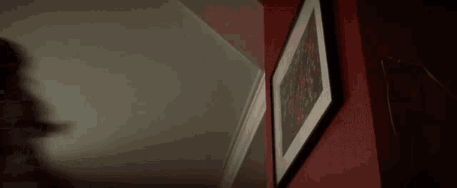a blurry picture of a person standing in a dark room .