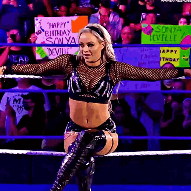a woman in a wrestling ring holding a sign that says happy birthday sonya