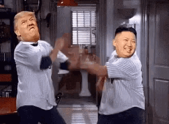 two men are standing next to each other in a room .