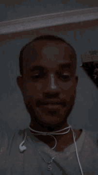 a man is wearing ear buds around his neck and smiling