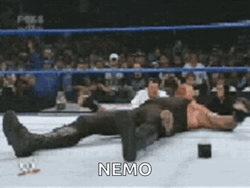 a man is laying on the ground in a wrestling ring with the word nemo written on the bottom