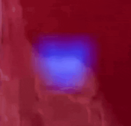 a blue light is shining in the dark with a black background