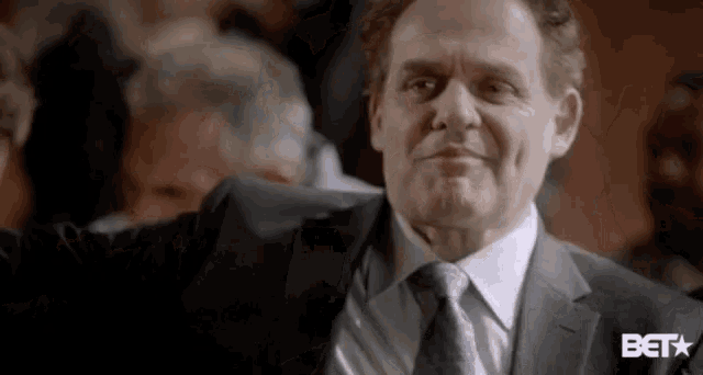 a man in a suit and tie is standing in a crowd of people .