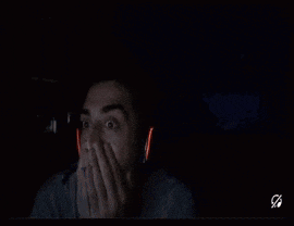 a man wearing headphones is looking at a computer screen in the dark