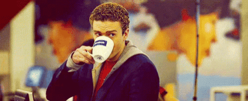 a man is drinking a cup of coffee .