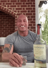 a man sitting at a table with a bottle of teremana