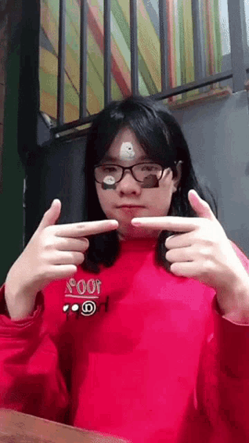 a girl wearing glasses and a red sweater with the word pooh on it