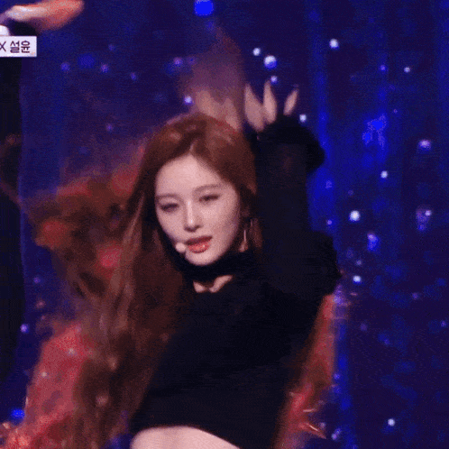 a woman with long hair is dancing on a stage