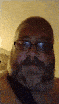 a man with a beard wearing glasses and a black tie