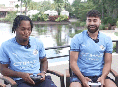 two men wearing etihad airways shirts sit in chairs