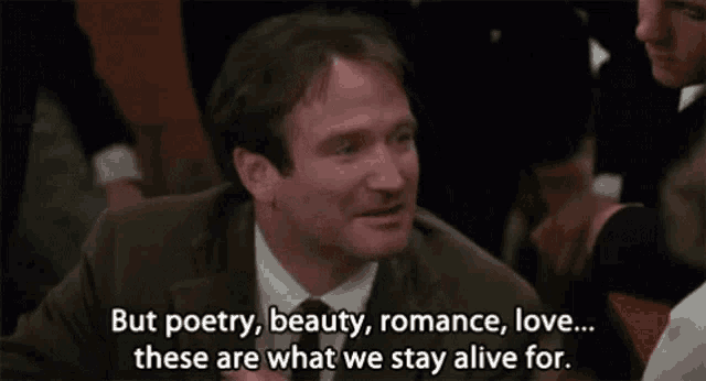 a man in a suit and tie is talking about poetry , beauty , romance , love