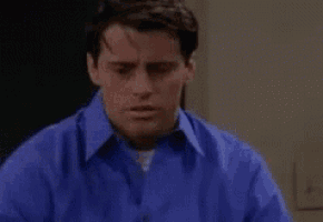 a close up of a man in a blue shirt making a face .