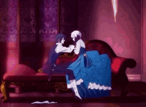 a man and a woman are holding hands while sitting on a couch .