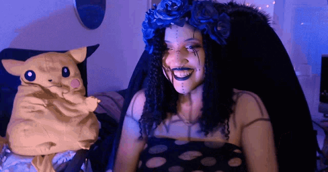 a woman with a crown of blue roses on her head is smiling