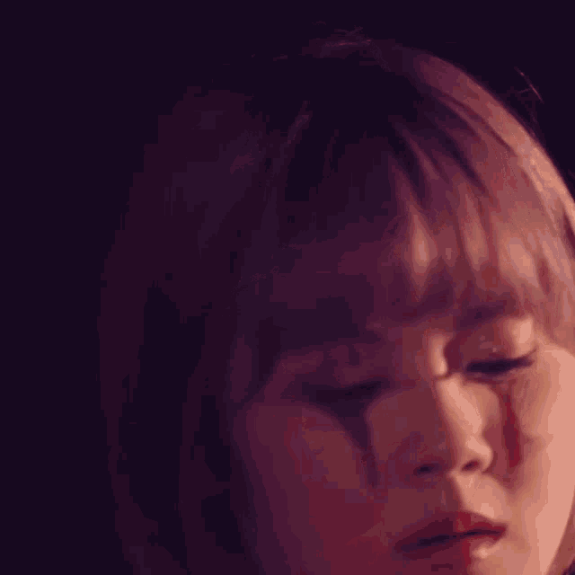a close up of a woman 's face with a tear running down her face .