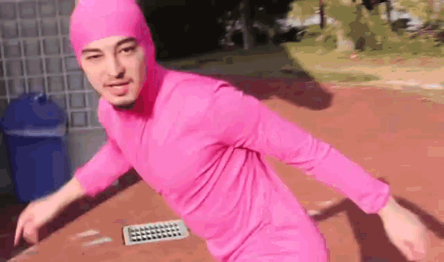 a man is wearing a pink suit and a pink hat