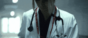 a doctor with a stethoscope around her neck has a lanyard around her neck with a red cross on it