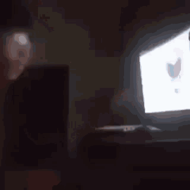 a person is playing a video game on a tv in the dark .