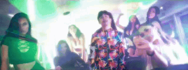 a group of people are dancing in a club in front of a disco ball .