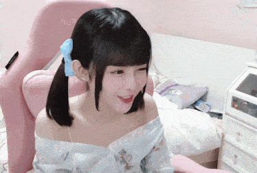 a girl is sitting in a pink chair with the letters ll on it