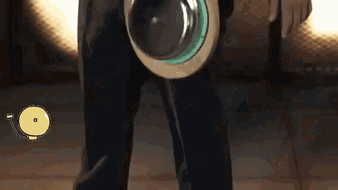 a person is holding a round object with a green ring around it and a yellow circle with the letter o on it