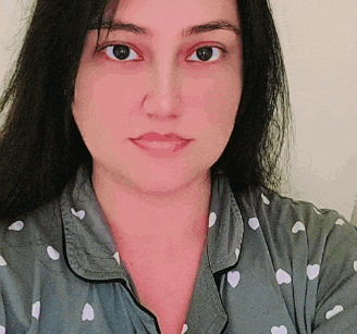 a close up of a woman 's face wearing a pajama top with hearts on it