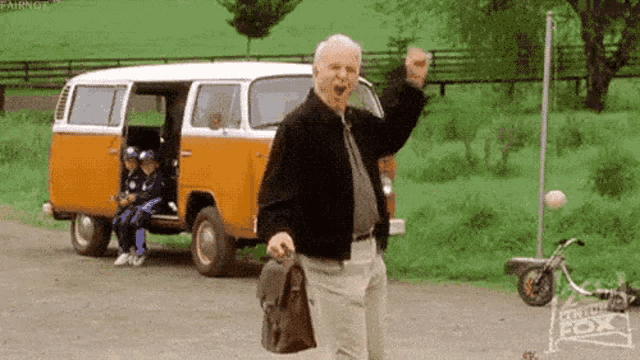 a man with a briefcase is standing in front of a van .