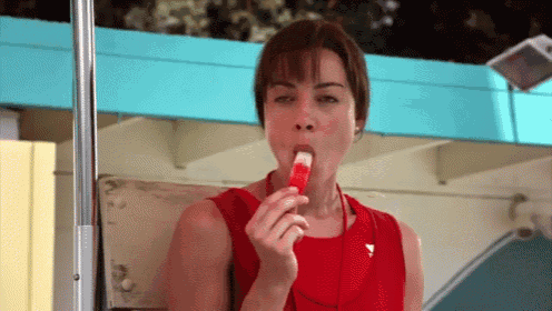 a woman in a red dress is eating an ice cream cone