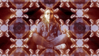 a woman sits in a lotus position in front of a kaleidoscope pattern