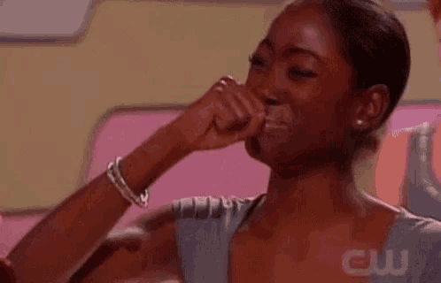 a woman is covering her mouth with her hand while crying .