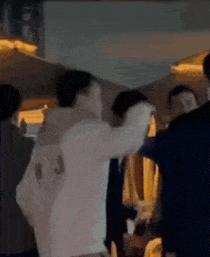 a group of people are standing in a room and one of them is holding another person 's head .