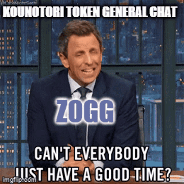 a man in a suit and tie is sitting in front of a sign that says " kounatori token general chat "