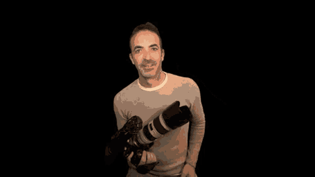 a man holding a camera giving a thumbs up