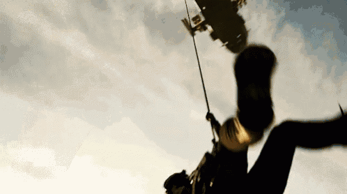 a person is hanging upside down from a rope in the sky