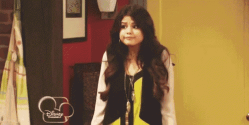 a girl is standing in front of a yellow door with a disney logo on it .