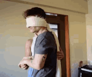 a man with his eyes blindfolded is standing next to a woman
