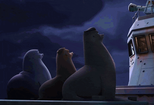 three seals are sitting on the side of a ship