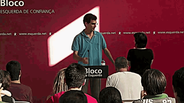 a man stands at a podium that says bloco