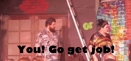 two men are standing next to each other in front of a brick wall and a sign that says `` you ! go get job ''
