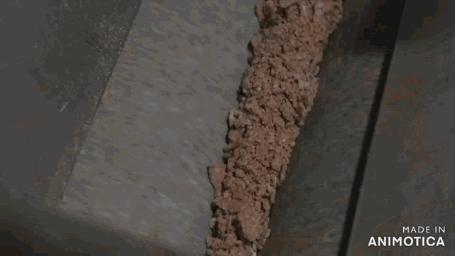 a tray of shredded food is being poured into a container that says made in animotica