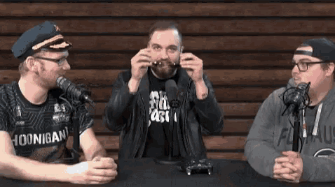 a man wearing a shirt that says hoonigan on it talks into a microphone