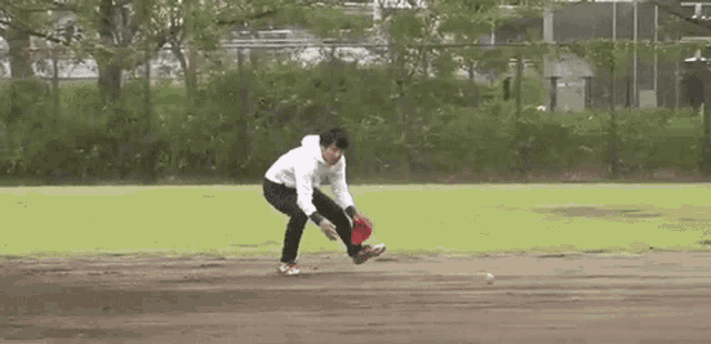 a man is catching a baseball with a glove on a field .