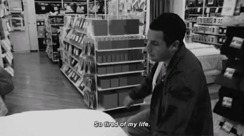 a black and white photo of a man in a store saying " so tired of my life "