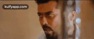 a man with a beard and mustache is making a funny face while wearing a white shirt .