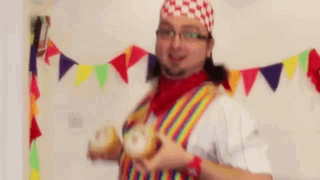 a man in a clown costume is holding a donut in his hand .