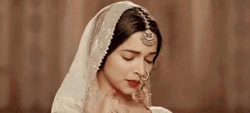 a close up of a woman wearing a nose ring and a veil .
