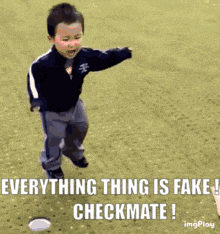 a little boy is running on a field with the caption everything thing is fake checkmate !