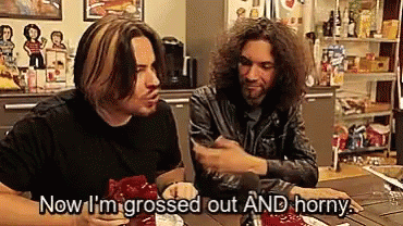two men are sitting at a table and one of them is saying now i 'm grossed out and horny