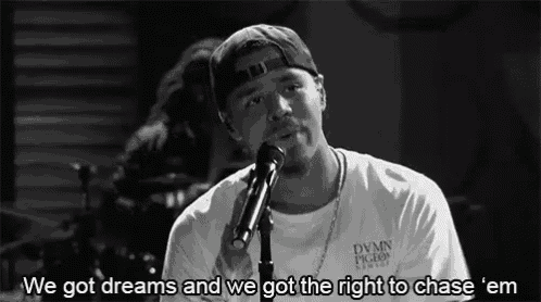 a man singing into a microphone with the words " we got dreams and we got the right to chase ' em " below him