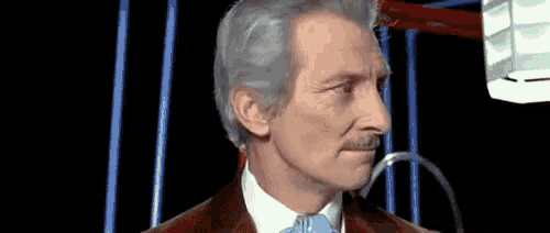 a man with gray hair and a mustache is looking at something